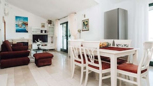A modern living room with a dining area, white furniture, and artwork on the walls. - Brdar Comfortable Holiday Residence (Marina)