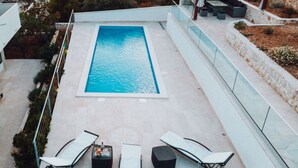 An outdoor swimming pool with lounge chairs and a pergola. - Brdar Comfortable Holiday Residence (Marina)