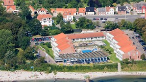 An aerial view of a coastal hotel with multiple buildings, a beach, and a pier. - 4 Person Holiday Park Home in Faaborg (Faaborg)