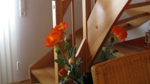 A wooden staircase with a flower arrangement on the landing. - Holiday Home Haus Mewa (Neuenkirchen)