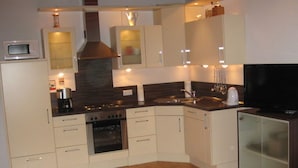 A modern kitchen with a microwave, stove, oven, sink, and a refrigerator. - Holiday Home Haus Mewa (Neuenkirchen)