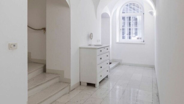 A narrow hallway with white walls and a tiled floor, leading to a staircase. - Perwanger Modern Retreat (Appiano Sulla Strada del Vino)