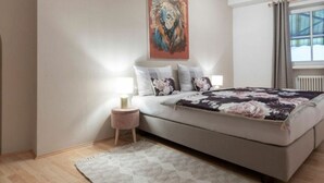 A bedroom with a large bed, a nightstand, a painting on the wall, and a window with curtains. - Perwanger Modern Retreat (Appiano Sulla Strada del Vino)