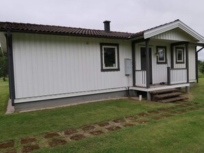A single-story house with a front porch, a chimney, and a small front yard with stepping stones. - 6 Person Holiday Home in Sunne (Sunne)