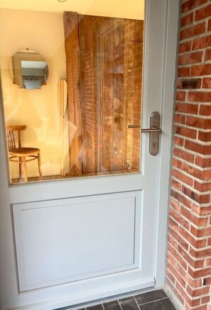 Une porte blanche avec un panneau en bois et une poignée en métal.