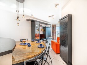 Une cuisine moderne dotée d’un plan de travail en granit, d’une table à manger avec des chaises et d’un four encastré.