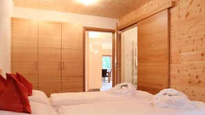 A bedroom with two beds, wooden wardrobes, and a door leading to another room. - Tasteful Apartment in Elzach-yach (Elzach)