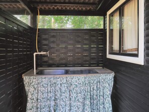 A small, enclosed bathroom with a sink, a window, and a view of greenery outside. - 4 Person Holiday Home in Rodby (Rodby)