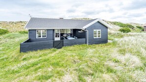 A dark-colored house with a sloped roof, a visible porch, and a small attached garage. - 6 Person Holiday Home in Henne (Henne)