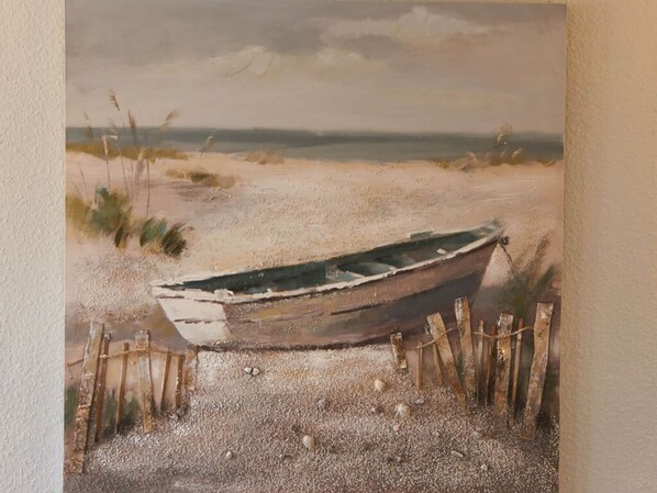 A painting of a boat on a sandy beach with a fence. - Holiday Home Magpie's Nest (Wusterwitz)