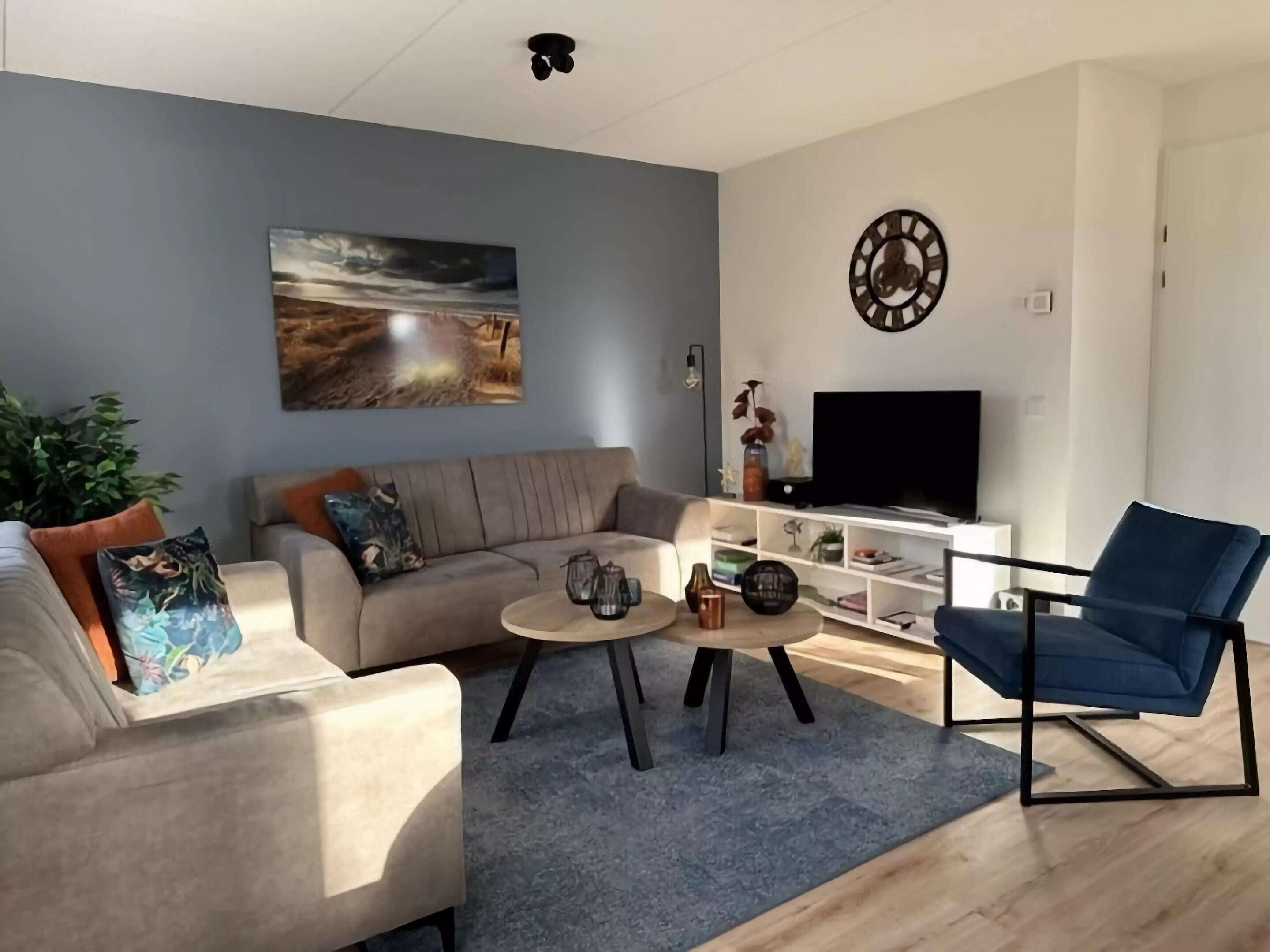 A modern living room with a sofa, coffee table, and a blue armchair.