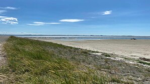 A beach with a clear sky and a path leading to the water.