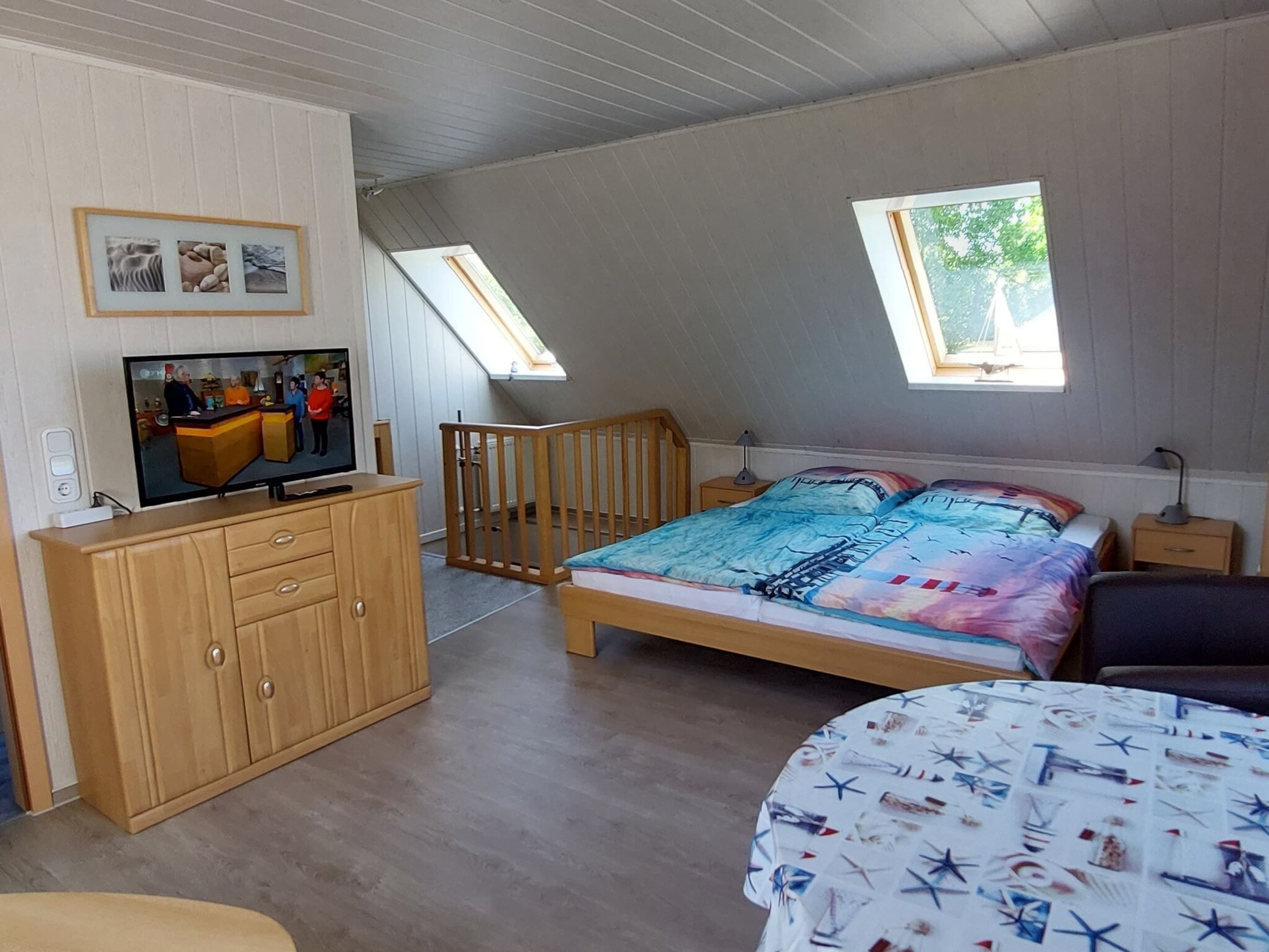 A room with a bed, a TV, a wooden cabinet, and a window.