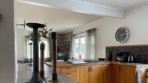Una cocina moderna con armarios de madera, encimera negra y un reloj de pared grande.