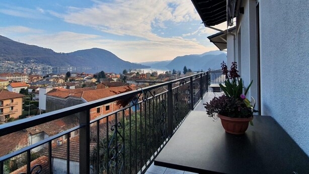 A balcony with a view of a town and mountains. - Belvilla by OYO Sweet Lake D'orta (Omegna)