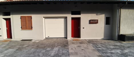 A building with a garage door, a red door, and a sign that reads "Sweet Lake".
