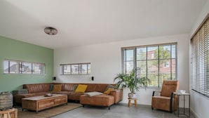 Amplia sala de estar con sofá modular, una mesita de centro y una planta en maceta.