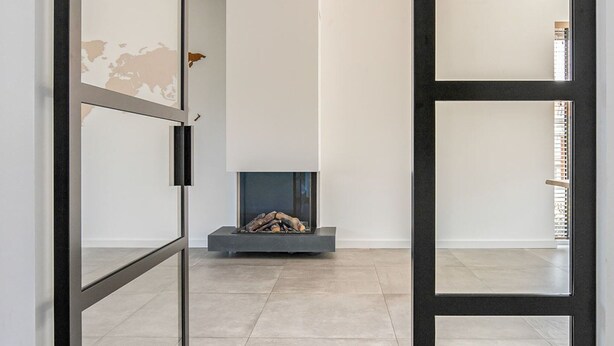Un interior moderno con chimenea, un mapa mundial en la pared y un diseño minimalista.