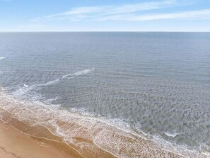 Una playa con olas suaves y cielo despejado.