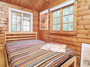 A wooden cabin room with a bed, two windows, and a poster on the wall. - 5 Person Holiday Home in Vejby (Vejby)