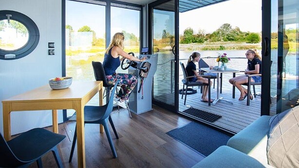 A modern interior with a dining area, a control station, and a view of the outdoors. - Nice Houseboat in Kinrooi for Rent (Kinrooi)