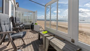 A deck with seating and a view of the beach. - Holiday Home in Dishoek by the Beach (Koudekerke)