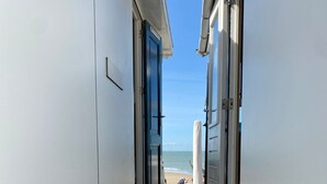 A narrow pathway leading to a beach with a surfboard visible. - Holiday Home in Dishoek by the Beach (Koudekerke)
