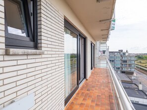 A balcony with a tiled floor, a glass door, and a window. - Cozy Studio on the 5th Floor With Terrace (Middelkerke)