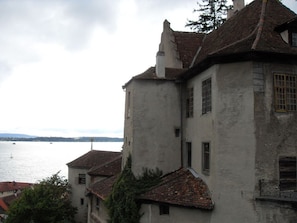 A historic building with a steep roof and a large window, overlooking a body of water. - Villa Lake Constance View (Stetten)
