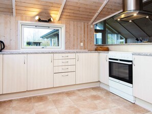 Una cocina con armarios de madera, una ventana y una estufa.