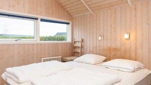 A bedroom with a bed, a window, and a wall-mounted light fixture. - 4 Star Holiday Home in Sydals (Sydals)