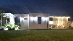 Un bâtiment moderne doté d’un toit plat, d’un petit porche et d’une entrée bien éclairée.