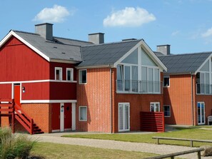 Een rij rode bakstenen gebouwen met een modern ontwerp, met grote ramen en een plat dak.