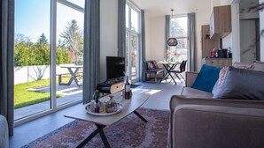A spacious living area with a large window, a dining table, and a sofa. - House With Dishwasher, in Nature Reserve (Rhenen)