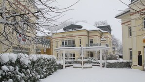 Un patio cubierto de nieve con un edificio que dice "Villa Sonja".