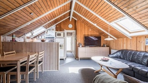 A cozy loft-style room with a dining area, a sofa, and a kitchen. - 4 Person Holiday Home in Hemmet (Hemmet)