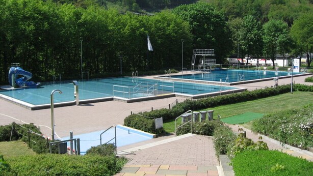 A swimming pool complex with multiple pools, a diving platform, and a water slide. - Eifel Farmhouse Comfortable Holiday Residence (Plütscheid)