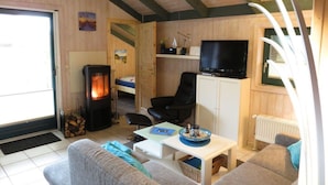 Una habitación acogedora con chimenea, televisión, sofá y una mesa de comedor.
