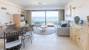 Een moderne woonkamer met een eethoek, een bank en uitzicht op zee.