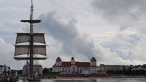 A tall ship docked at a harbor with historic buildings in the background. - Modern Apartment Near Seabeach (Binz)
