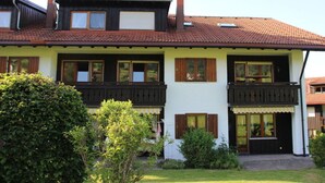 A two-story house with a red-tiled roof, wooden balconies, and a well-maintained garden. - Hochgrat View in Steibis, Haus Akelei (Oberstaufen)