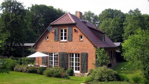 A brick house with a sloped roof, multiple windows, and a satellite dish. - Old Zerwelin Forestry Company (Nordwestuckermark)