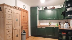 A kitchen with wooden cabinets, a sink, and a dishwasher. - Old Zerwelin Forestry Company (Nordwestuckermark)