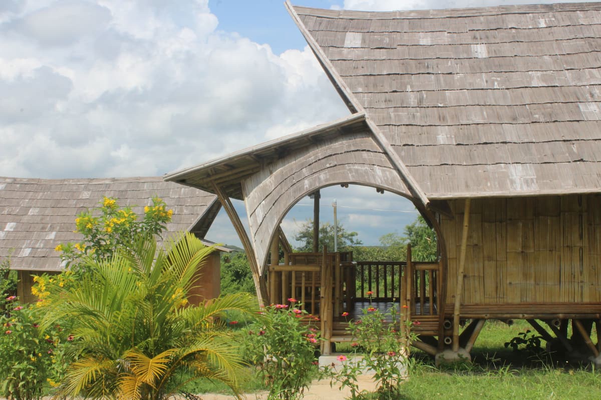 A rustic wooden structure with a sloped roof and an arched entrance.