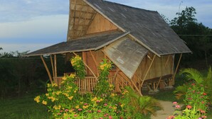 A wooden house with a sloped roof and a porch. - Hanchey Bamboo Resort  (Stueng Trang)