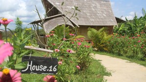 A rustic house with a sign reading "House.16" amidst a garden with various flowers and plants. - Hanchey Bamboo Resort  (Stueng Trang)