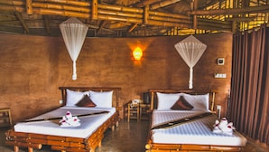 Two wooden beds with white linens and decorative pillows, a wall-mounted light, and a bamboo ceiling. - Hanchey Bamboo Resort  (Stueng Trang)