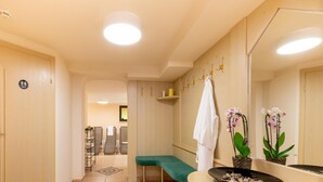 A hotel bathroom with a bench, a sink, a mirror, and a towel rack. - Property in Langenfeld (Laengenfeld)