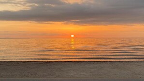A sunset over a calm sea with a beach in the foreground. - Villa in Patras With Pool Near Beach (Patras)