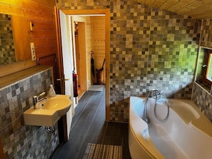 A bathroom with a sink, bathtub, and a patterned wall. - Inviting Apartment in Schotten (Schotten)